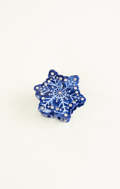 Blue snowflake-shaped object with rhinestones on a white background