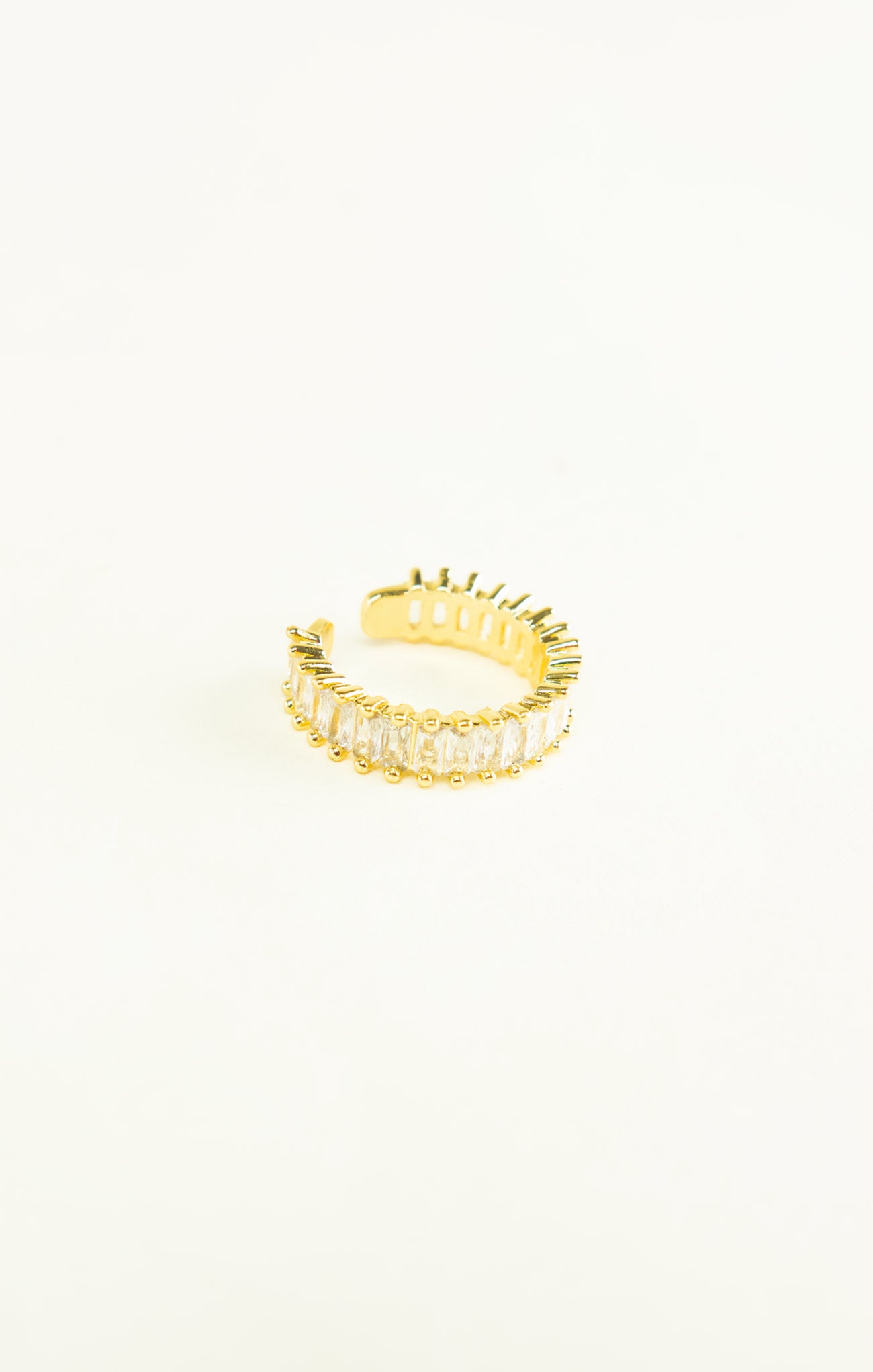 Gold ring with a textured design on a white background