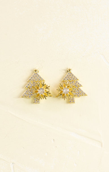 Gold tree-shaped earrings with clear stones on a beige background