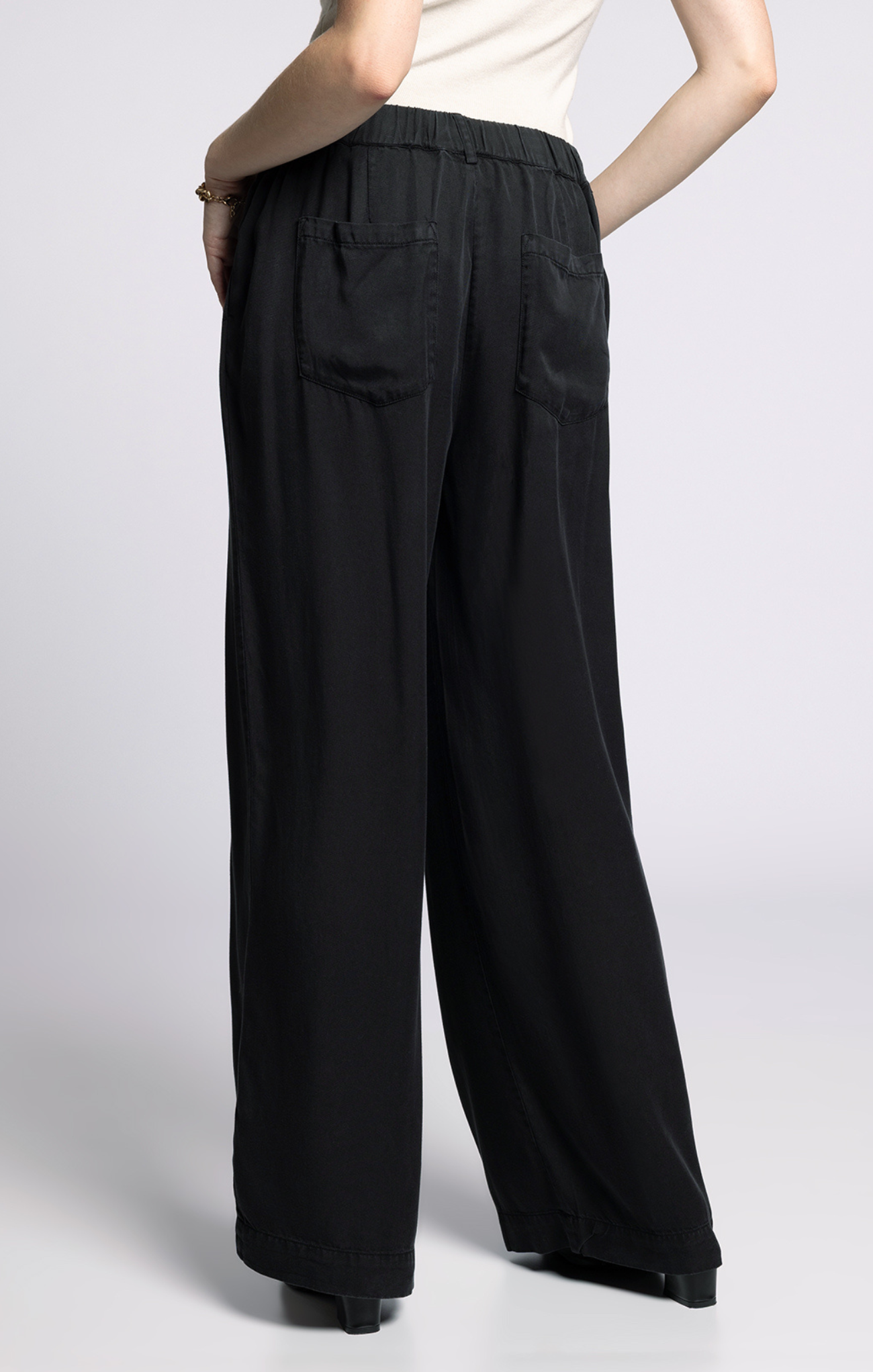 Black wide-leg pants worn by a person on a light gray background
