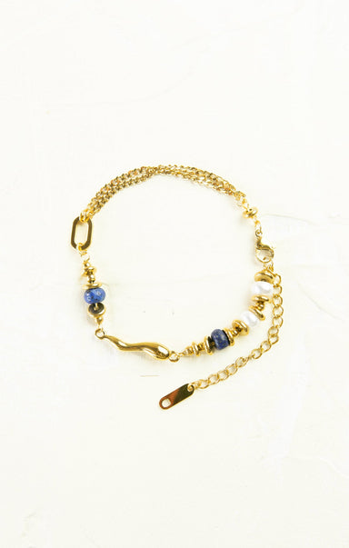 Gold bracelet with blue beads on a white background