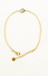 Gold anklet with turquoise flower charm on a white background