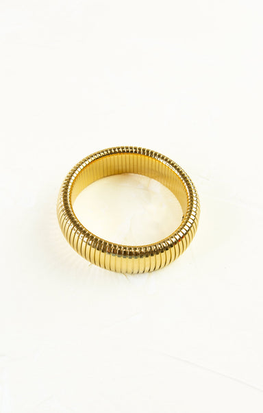 Gold ring with a ribbed design on a white background