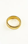 Gold ring with a ribbed design on a white background