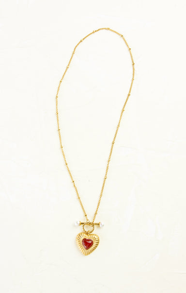 Gold necklace with a heart-shaped pendant on a white background