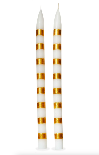 Two white candles with gold stripes on a white background