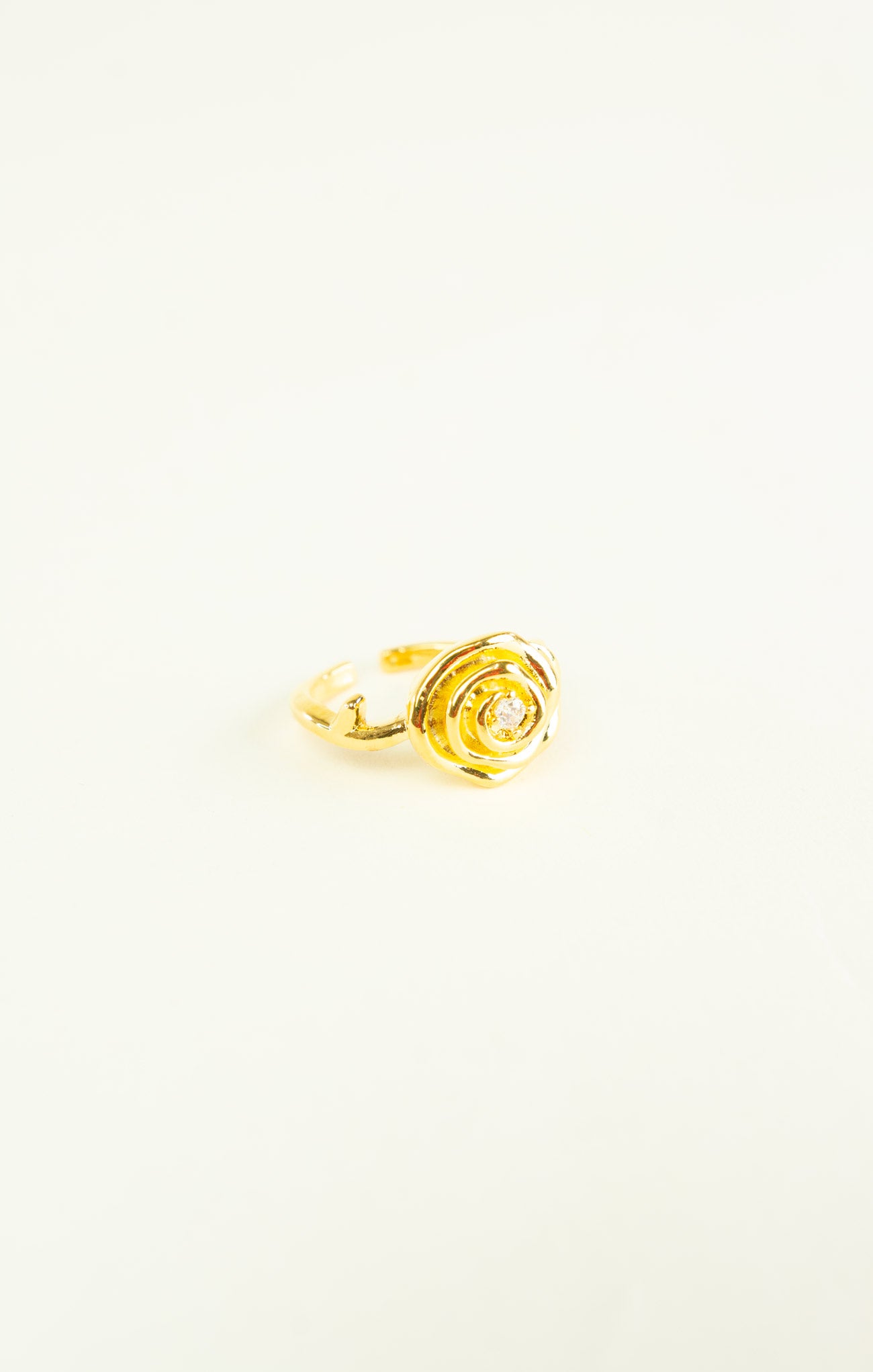 Gold rose-shaped ring on a white background