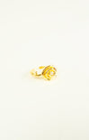 Gold rose-shaped ring on a white background