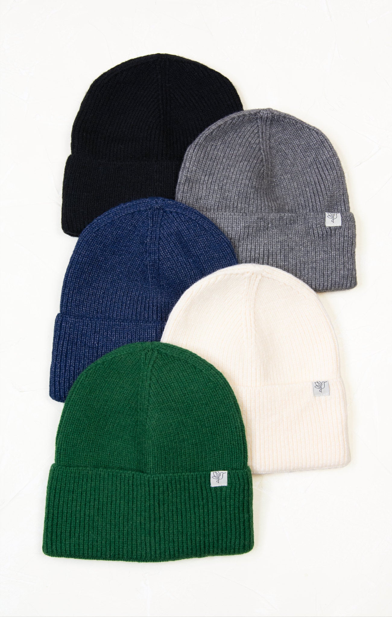 Five knit beanie hats in black, gray, blue, green, and white on a white background.