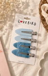 Set of blue hair clips on a 'Lovebird' branded card with a soft background.