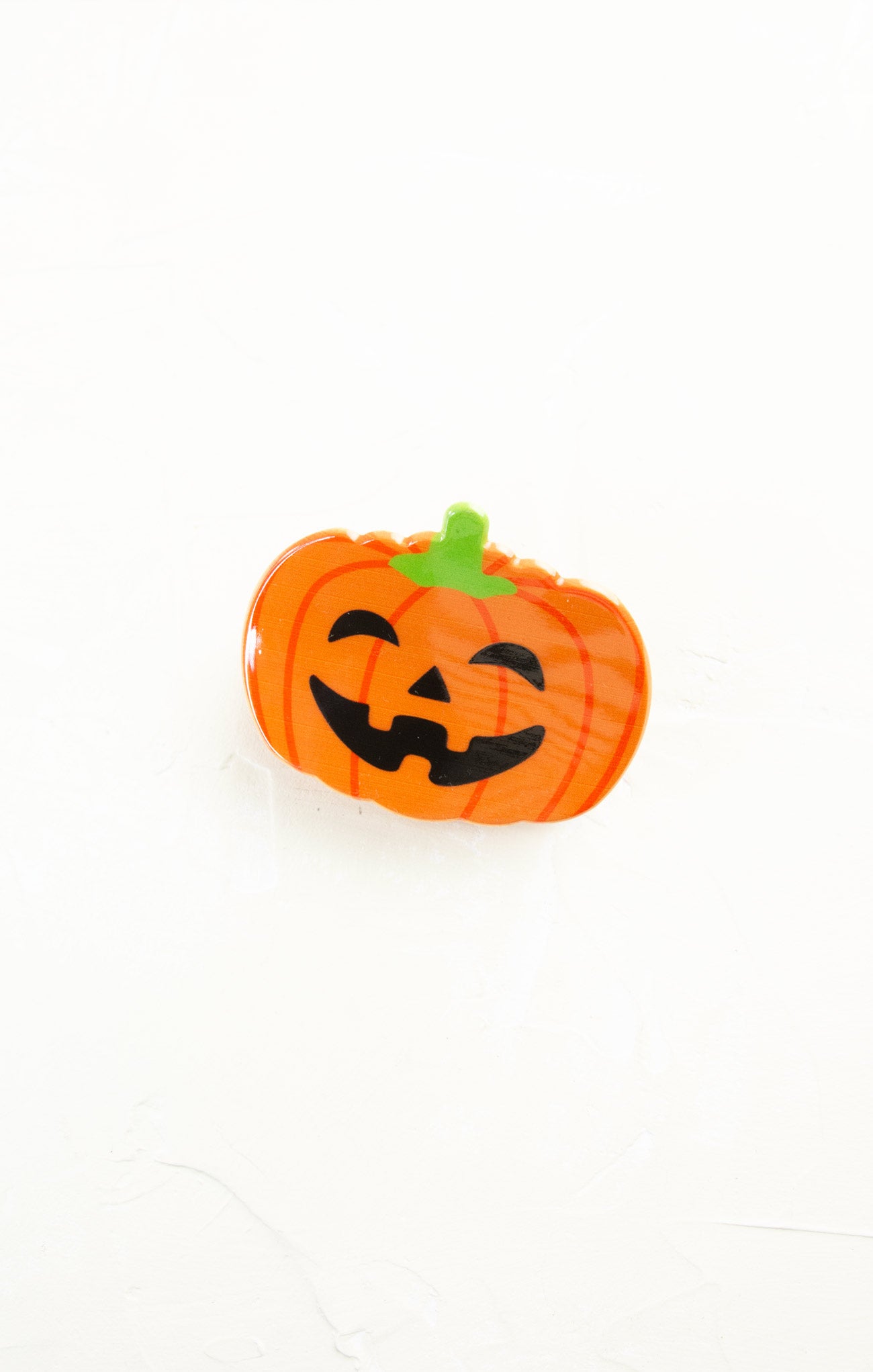 Pumpkin-shaped object with a smiling face on a white background