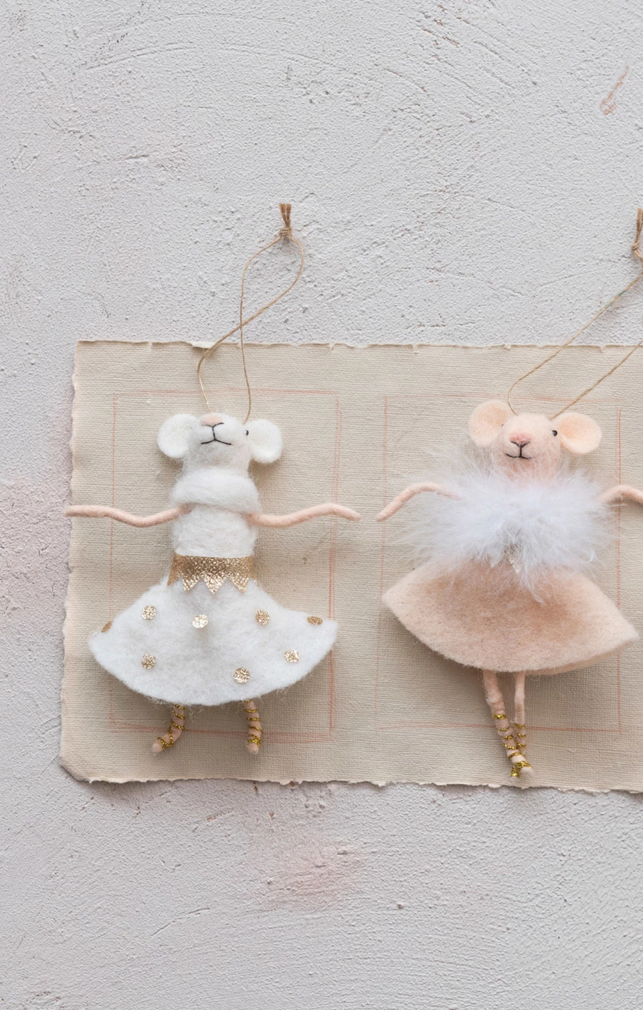 Two mouse figurines in ballet costumes on a textured surface