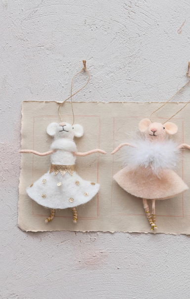 Two mouse figurines in ballet costumes on a textured surface
