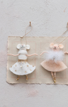 Two mouse figurines in ballet costumes on a textured surface