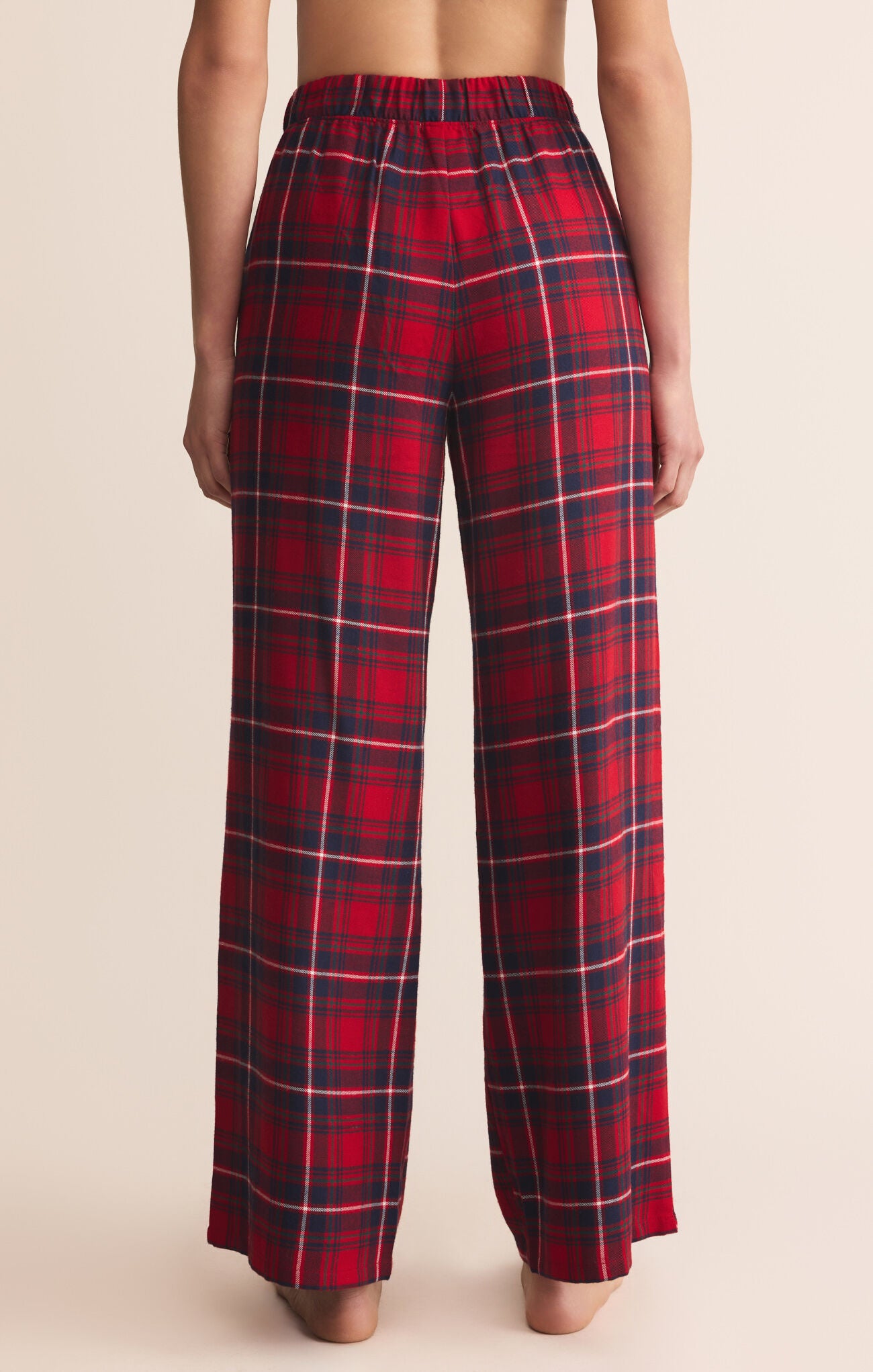 Red plaid pants worn by a person on a beige background