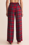 Red plaid pants worn by a person on a beige background