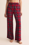 Red plaid pajama pants worn by a person on a beige background
