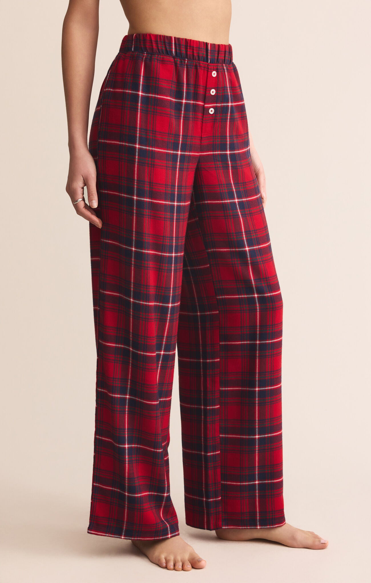 Red and black plaid pajama pants on a beige background