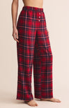 Red and black plaid pajama pants on a beige background