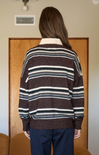 Person wearing a striped sweater with a neutral background