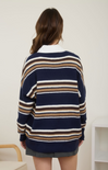Person wearing a navy blue and brown striped sweater with a white collar.