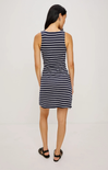 Woman wearing a navy and white striped dress on a plain background