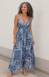 Woman wearing a blue and white patterned dress against a plain background