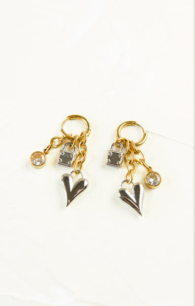 Pair of gold and silver earrings with heart-shaped charms on a white background