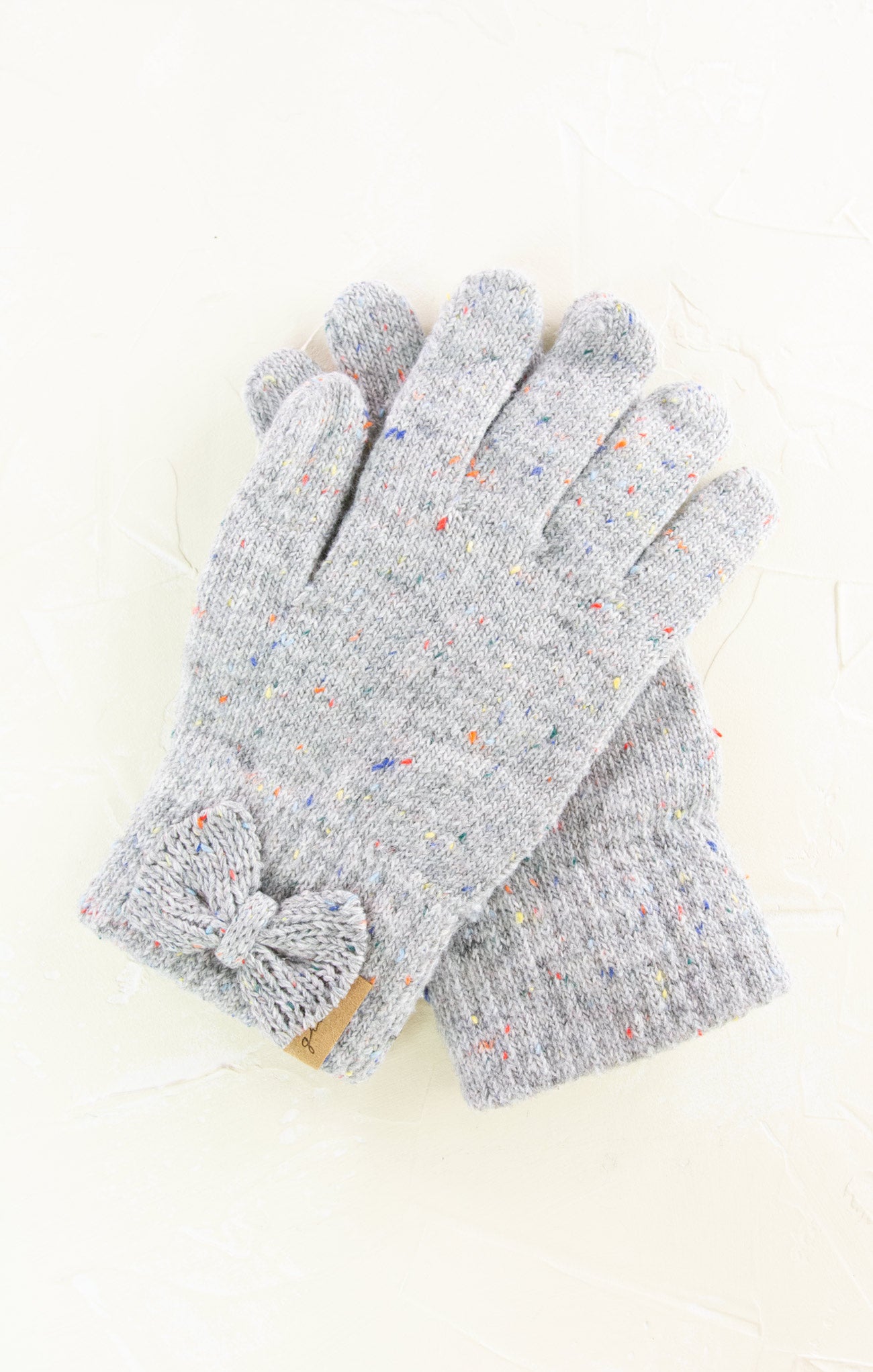 Pair of gray gloves with colorful speckles on a white background