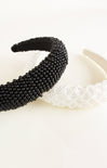 Black beaded headband and white lace headband on a light background