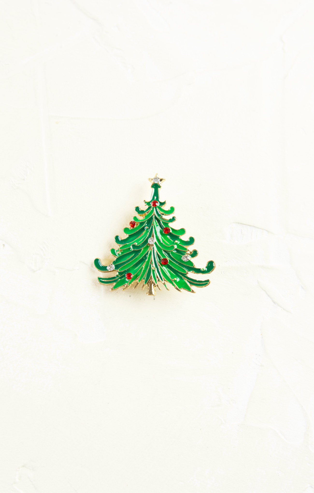 Green Christmas tree brooch with red berries on a white background