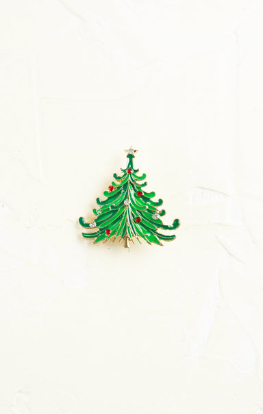 Green Christmas tree brooch with red berries on a white background