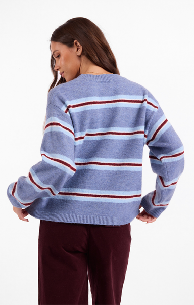 Woman wearing a blue and red striped sweater on a white background