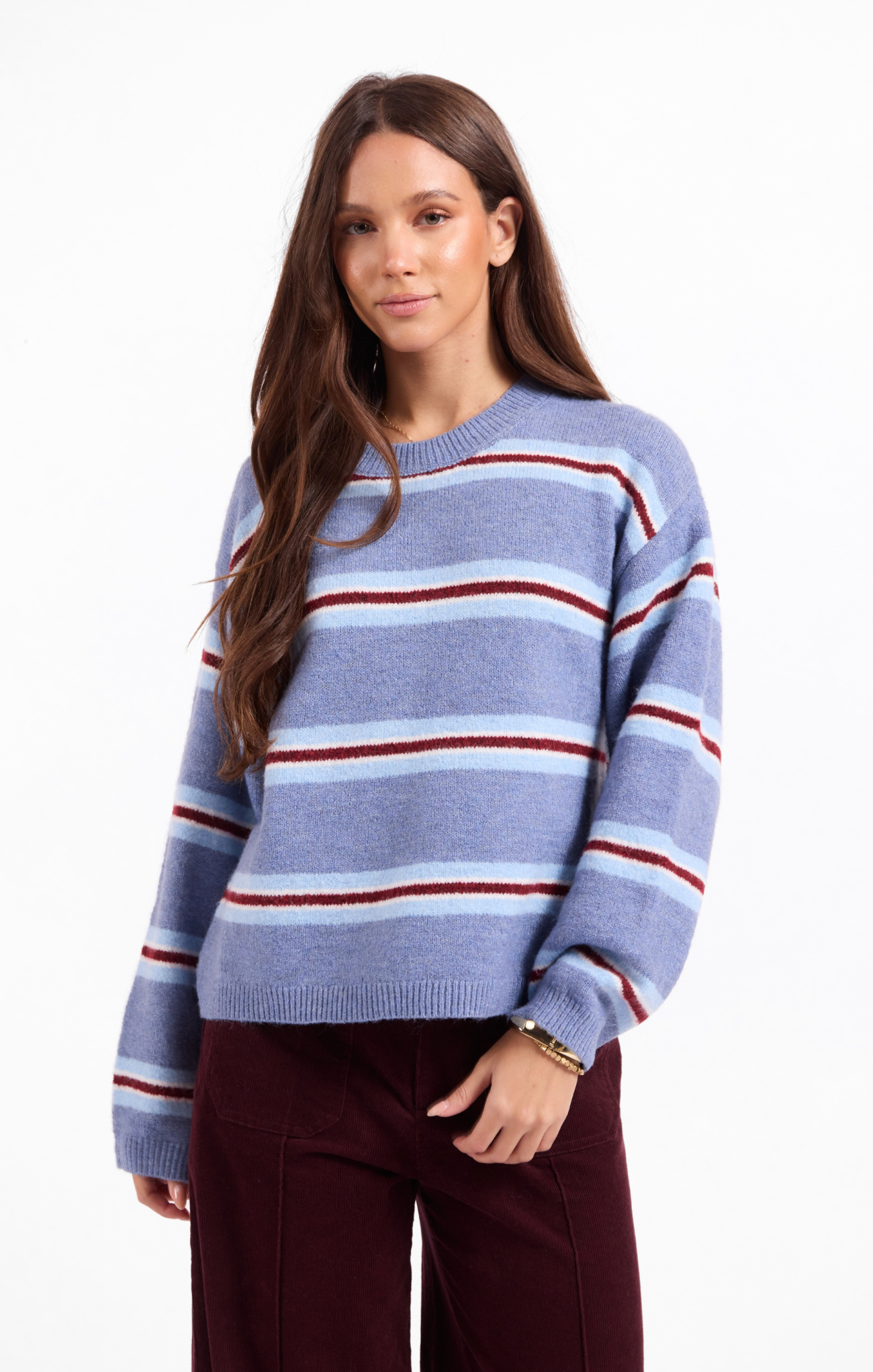 Woman wearing a blue and red striped sweater on a white background