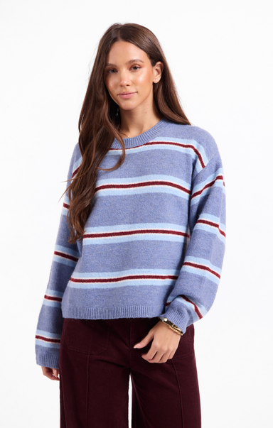 Woman wearing a blue and red striped sweater on a white background