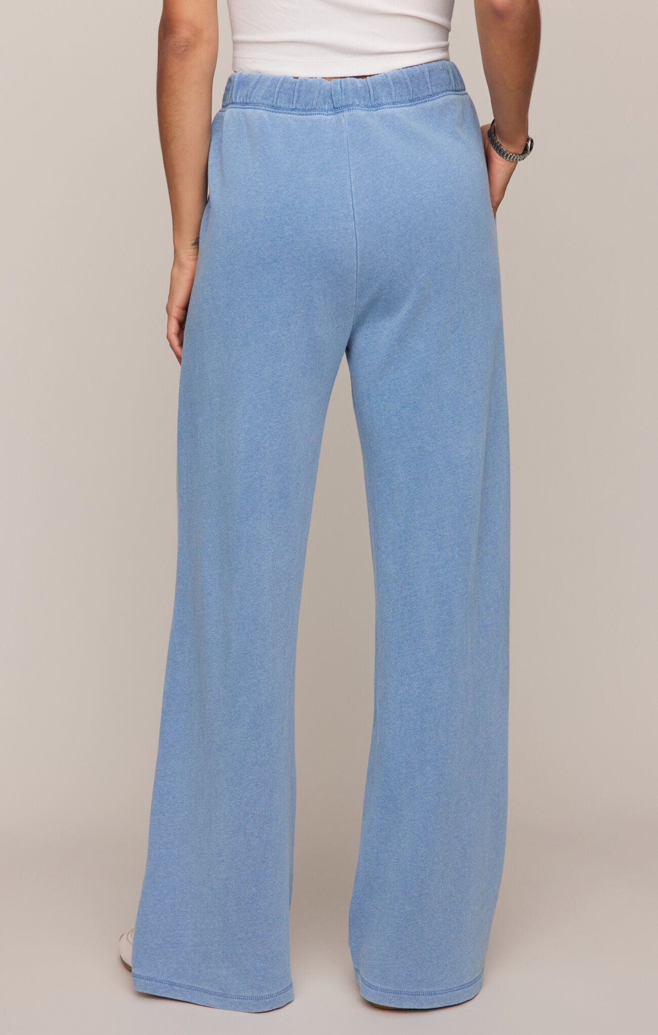 Light blue pants worn by a person on a beige background