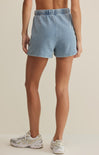 Light blue denim shorts worn by a person on a beige background