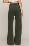 Person wearing green wide-leg pants on a beige background
