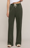 Person wearing green pants with a drawstring on a plain background