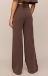 Brown wide-leg pants worn by a person on a beige background