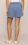 Person wearing blue denim shorts on a beige background