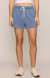 Person wearing blue shorts with a beige background