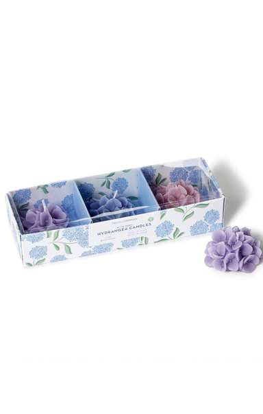 Set of purple candles in a decorative box with floral design on a white background