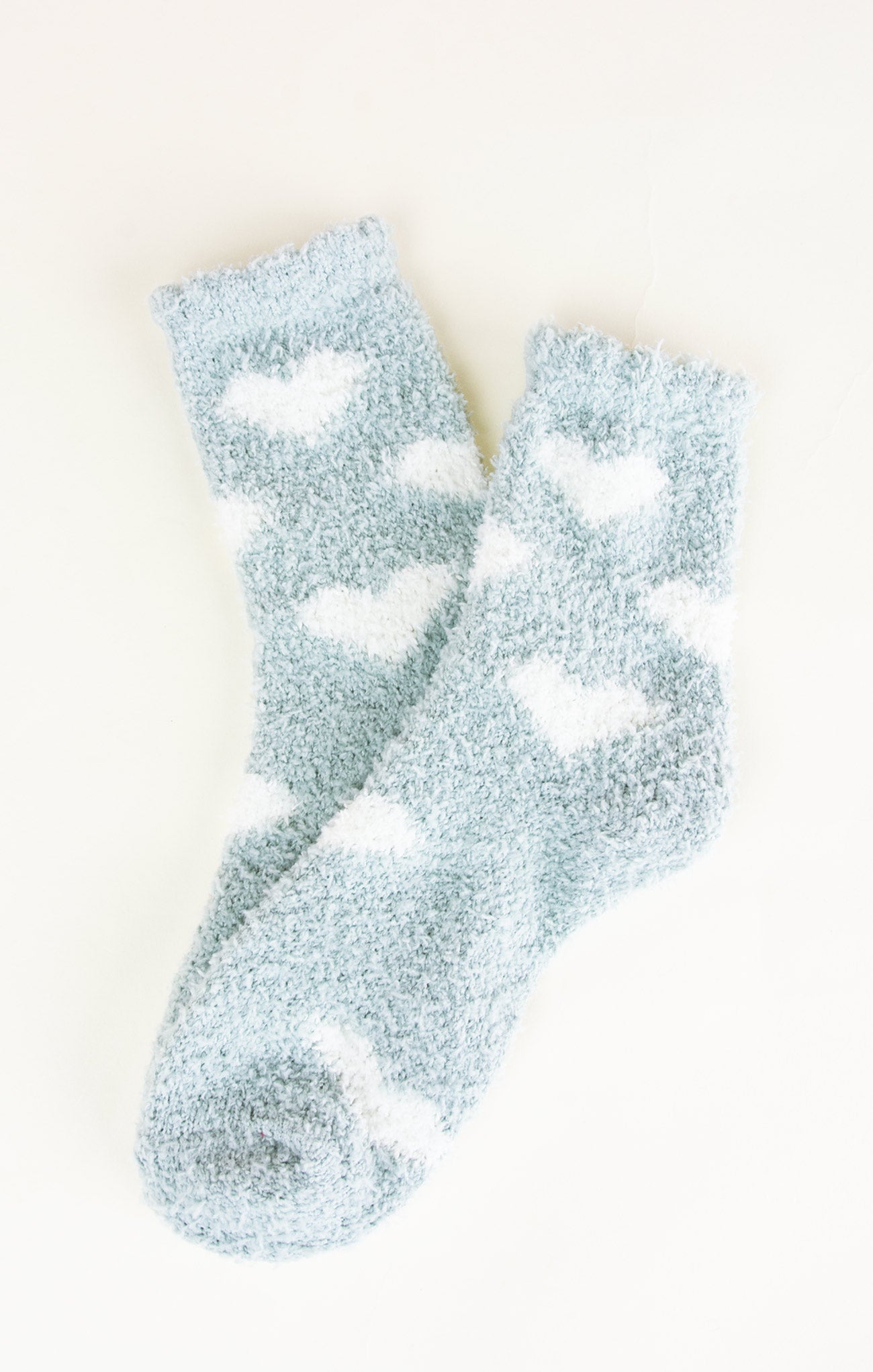 Light blue socks with white cloud patterns on a light beige background