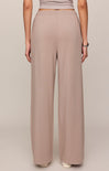 Person wearing beige wide-leg pants on a plain background