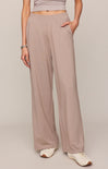 Person wearing light brown wide-leg pants on a plain background
