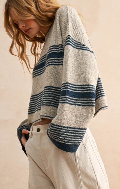 Person wearing a striped sweater with a neutral background