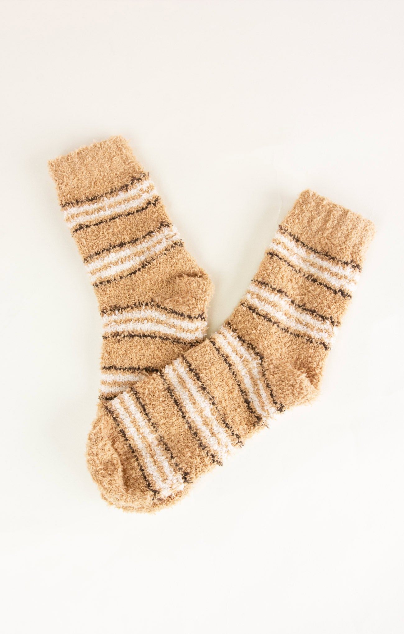 Pair of beige and white striped socks on a white background