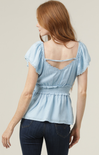 Light blue ruffled blouse worn by a person on a neutral background