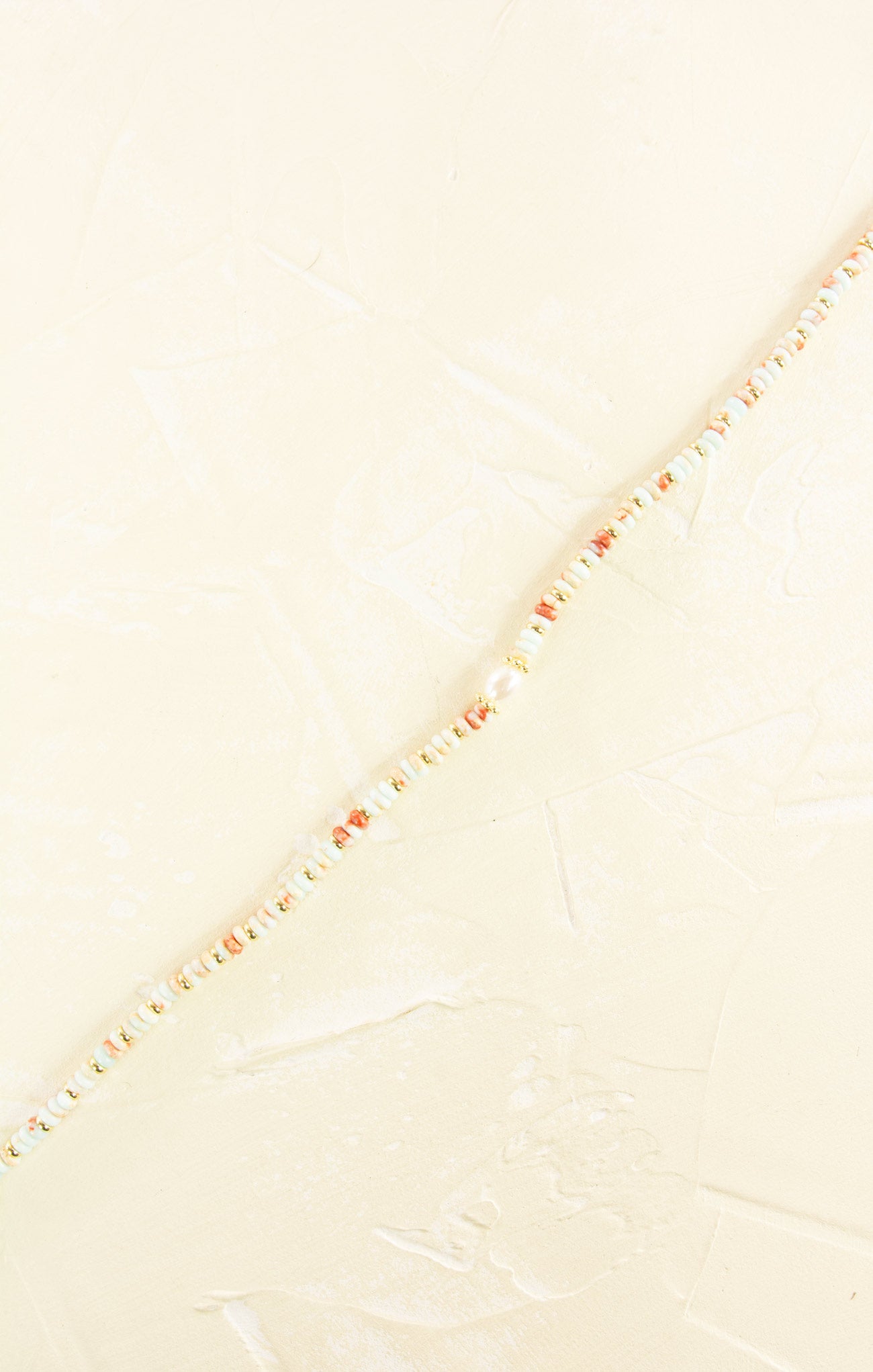 Close-up of a textured fabric with a subtle pattern on a light beige background